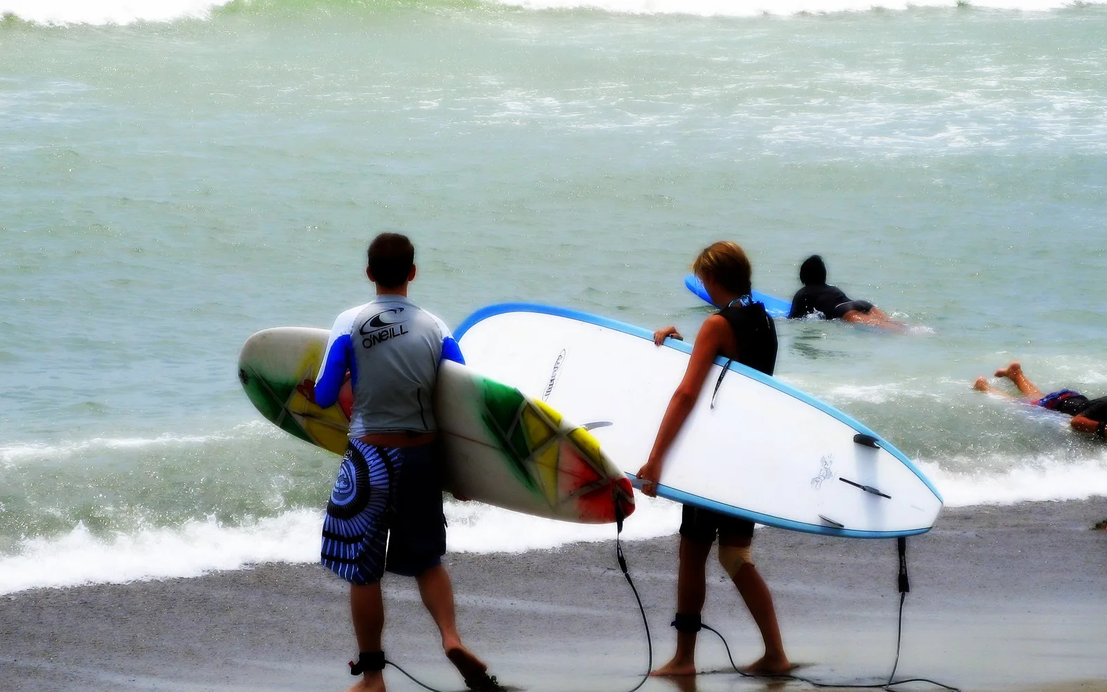 Surfers in the water at Doheny Beach with waves in the background